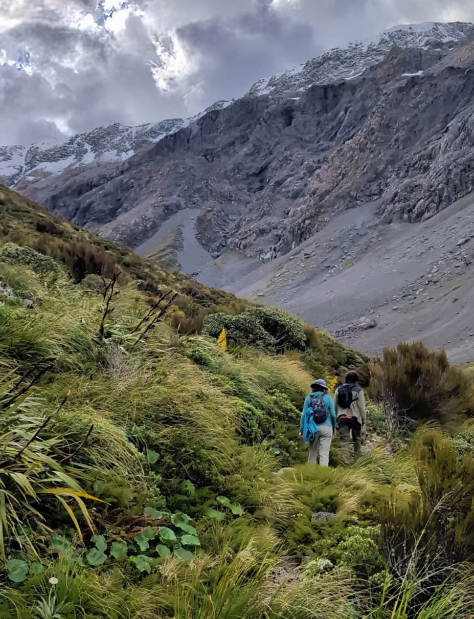Olga walking alongside a colleague on a mountain hike.