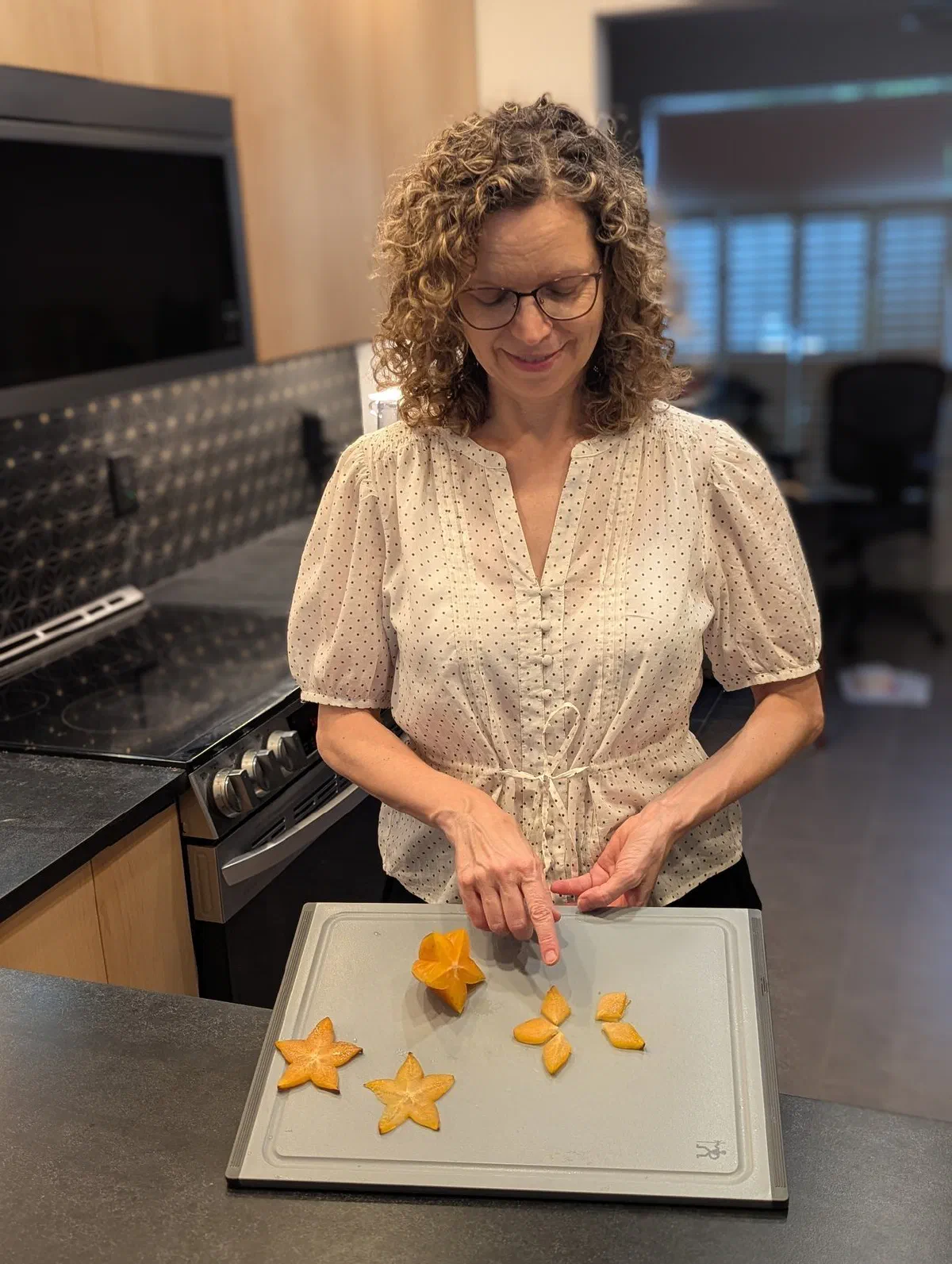 Olga in the kitchen showing a fraction lesson with sliced star fruit.